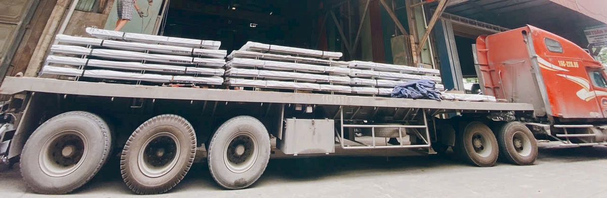 Thép xếp trên rơ-moóc chờ giao